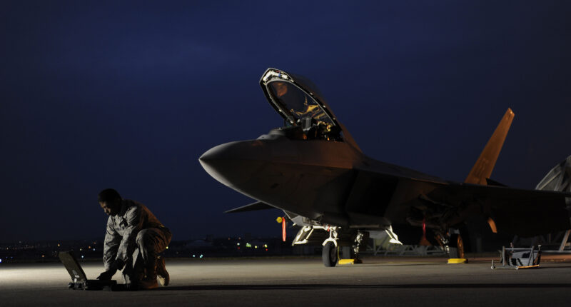 U.S. Air Force Airman 1st Class Aaron Tate enters data into his portable maintenance computer in front of an F-22A Raptor aircraft at Kadena Air Base, Japan, on Jan. 21, 2009. Tate and the jet are deployed from the 27th Fighter Squadron at Langley Air Force Base, Va. (DoD photo by Master Sgt. Andy Dunaway, U.S. Air Force. (Released))