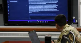 U.S. Army officer reviews AI-generated doctrine content on a large screen at Fort Leavenworth.