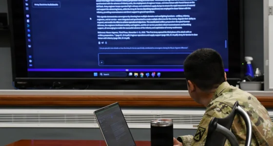 U.S. Army officer reviews AI-generated doctrine content on a large screen at Fort Leavenworth.