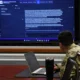 U.S. Army officer reviews AI-generated doctrine content on a large screen at Fort Leavenworth.
