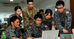U.S., South Korean, and Japanese personnel collaborate during a planning session at Exercise Cobra Gold, supporting multinational coordination on space and operational technologies.