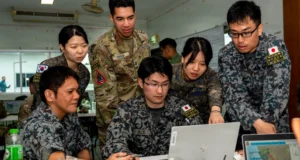 U.S., South Korean, and Japanese personnel collaborate during a planning session at Exercise Cobra Gold, supporting multinational coordination on space and operational technologies.
