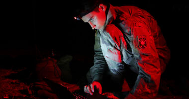 A student assigned to the U.S. Army John F. Kennedy Special Warfare Center and School, who is in the Special Forces Communications Sergeant course, uses a PDA-184 computer during nighttime antenna training at Fort Bragg, North Carolina August 30, 2019. The training qualified students in the high frequency communications module which trained them to be proficient in making, installing, operating and maintaining short-, medium-, and long-range antennas in order to communicate at long distances. (U.S. Army photo by K. Kassens)
