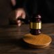 Close-up of a judge’s gavel striking a sound block during a courtroom proceeding.