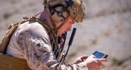 U.S. Marine operating a handheld device in a field training environment