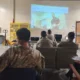 Military personnel attending a medical training session with a projected instructional screen