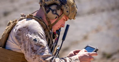 U.S. Marine operating a handheld device in a field training environment