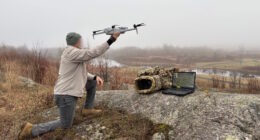Operator deploying drone with AI edge processing system for real-time landmine detection in field environment