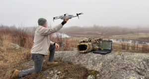 Operator deploying drone with AI edge processing system for real-time landmine detection in field environment