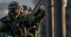 South Korean soldiers patrol a border fence during a military operation.