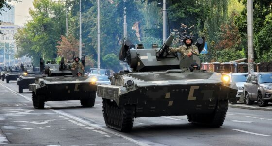 Ukrainian armored vehicles driving through a city street during military operations.