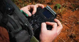 US Army drone operator using a handheld UAV controller during counter-drone testing operations.