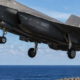 A US Navy F-35C launches from an aircraft carrier during flight operations.