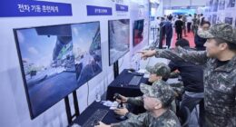 South Korean soldiers interact with battlefield simulation technology showcased by SK Telecom.